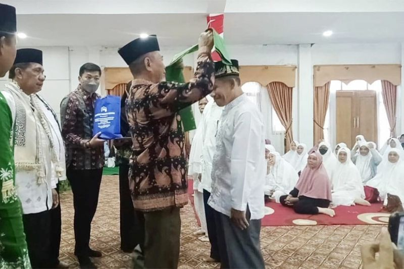 Bupati Merangin H Mashuri sedang memasang syal kepada salah seorang perwakilan calon jamaah haji asal daerah itu./ Foto : ANTARA