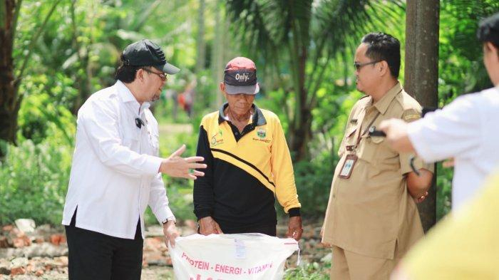 Ivan Wirata serahkan bantuan bibit dan pakan ikan pada kelompok tani di Desa Sungai Duren, Kecamatan Jambi Luar Kota, Kabupaten Muarojambi, Selasa (13/12/22). 