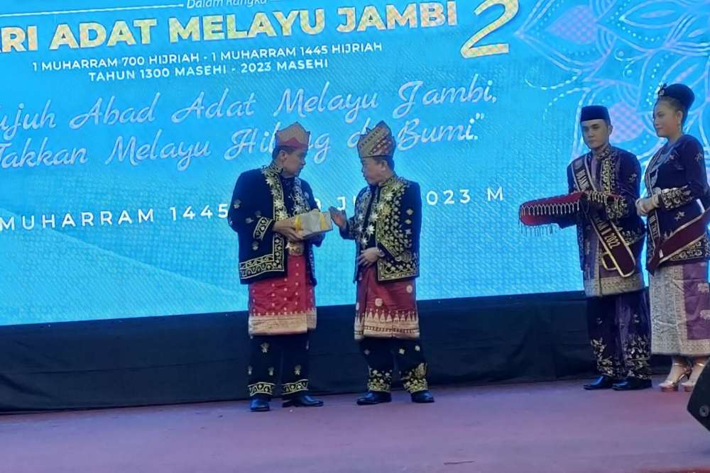 Ketua Umum LAM Provinsi Jambi Hasan Basri Agus menyerahkan buku daras adat Melayu Jambi kepada Gubernur Jambi Al Haris