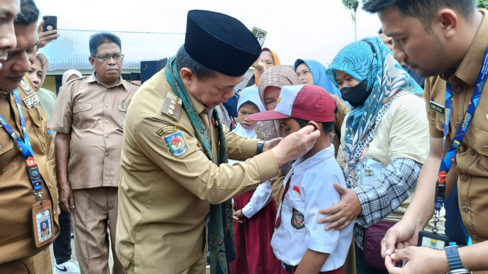 Gubernur Jambi Al Haris menyerahkan bantuan dengar kepada Alfikhoiri salah seorang siswa SLB Kabupaten Batanghari penerima bantuan Dumisake Pendidikan 2023.