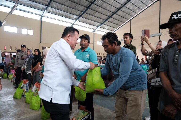 Gubernur Al Haris menyerahkan bantuan sembako kepada warga.