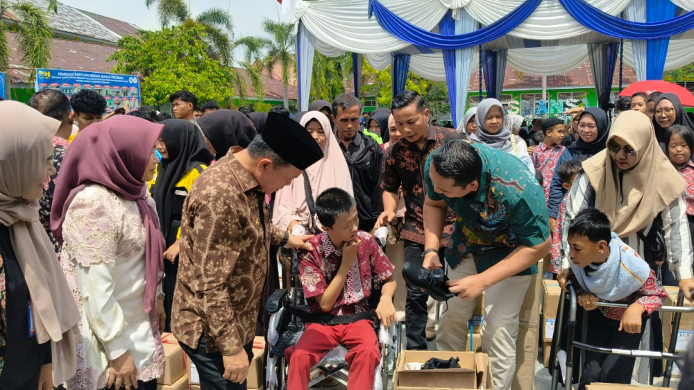 Gubernur Jambi Al Haris didampingi Bupati Merangin Syukur menyerahkan bantuan Dumisake Pendidikan di Merangin.