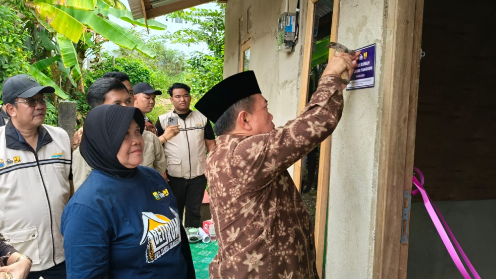 Gubernur Jambi Al Haris memasang plat peneng bedah rumah di Bangko.